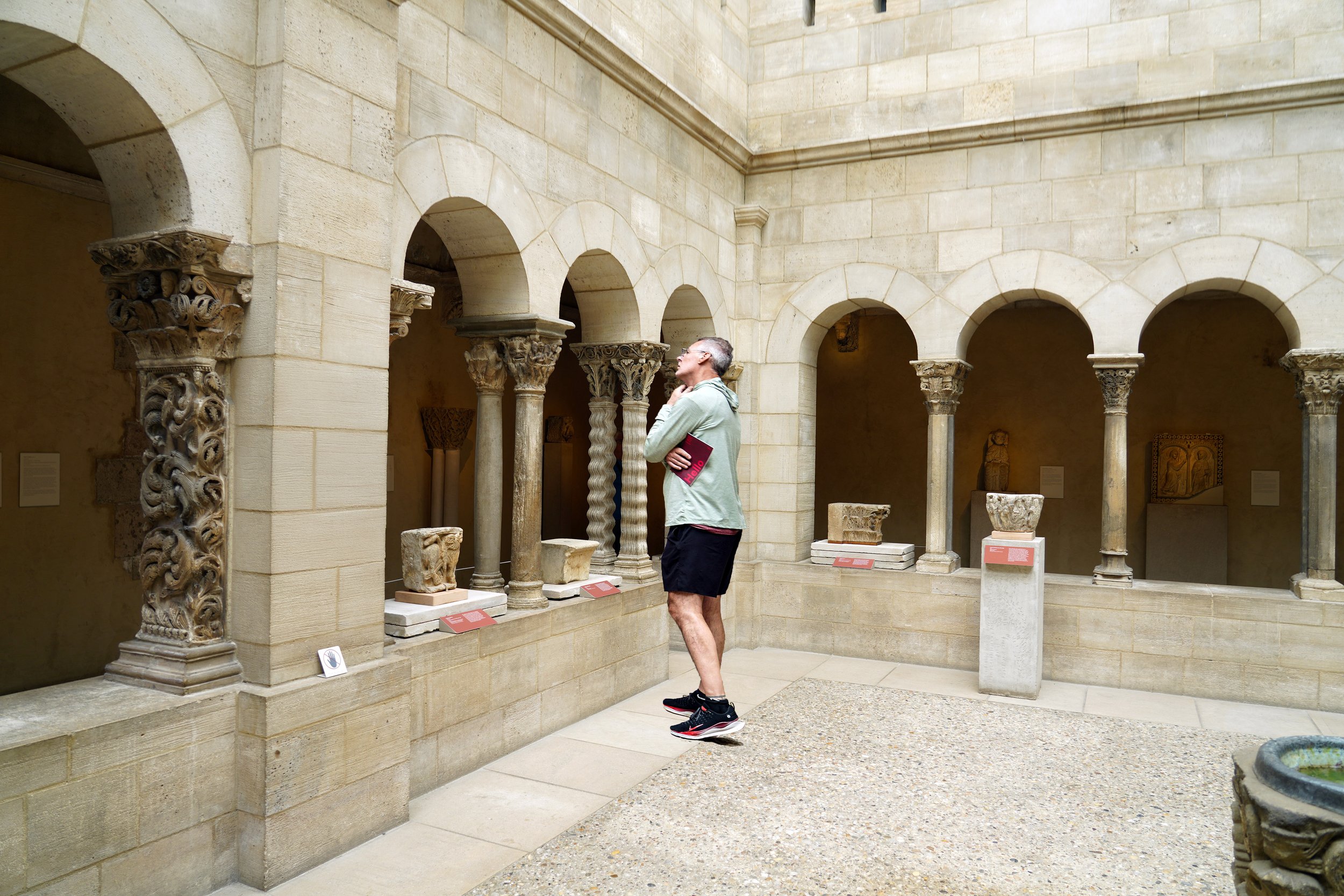 Tourist views the capital with 'Mouth of Hell' in the Cloisters courtyard.