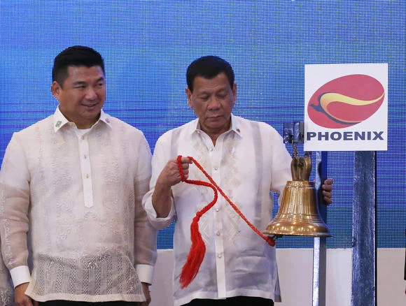 Philippine tycoon Dennis Uy, left, says he feels confident investing with President Rodrigo Duterte, right, in power. © AP