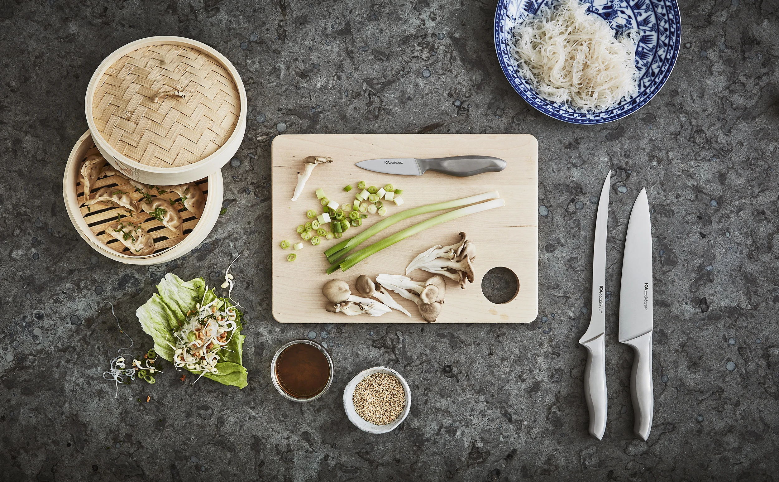 Köksredskap och råvaror på mörk bänkskiva av sten i kök