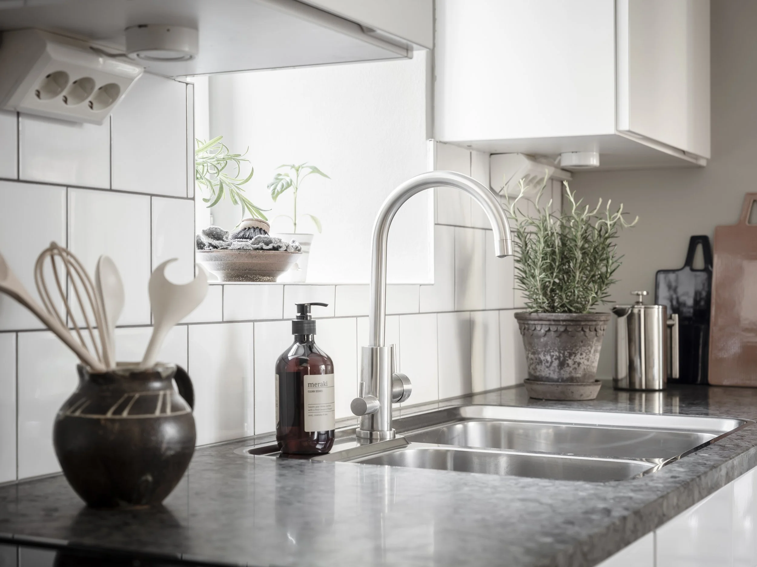 Kök med diskho och bänkskiva i sten