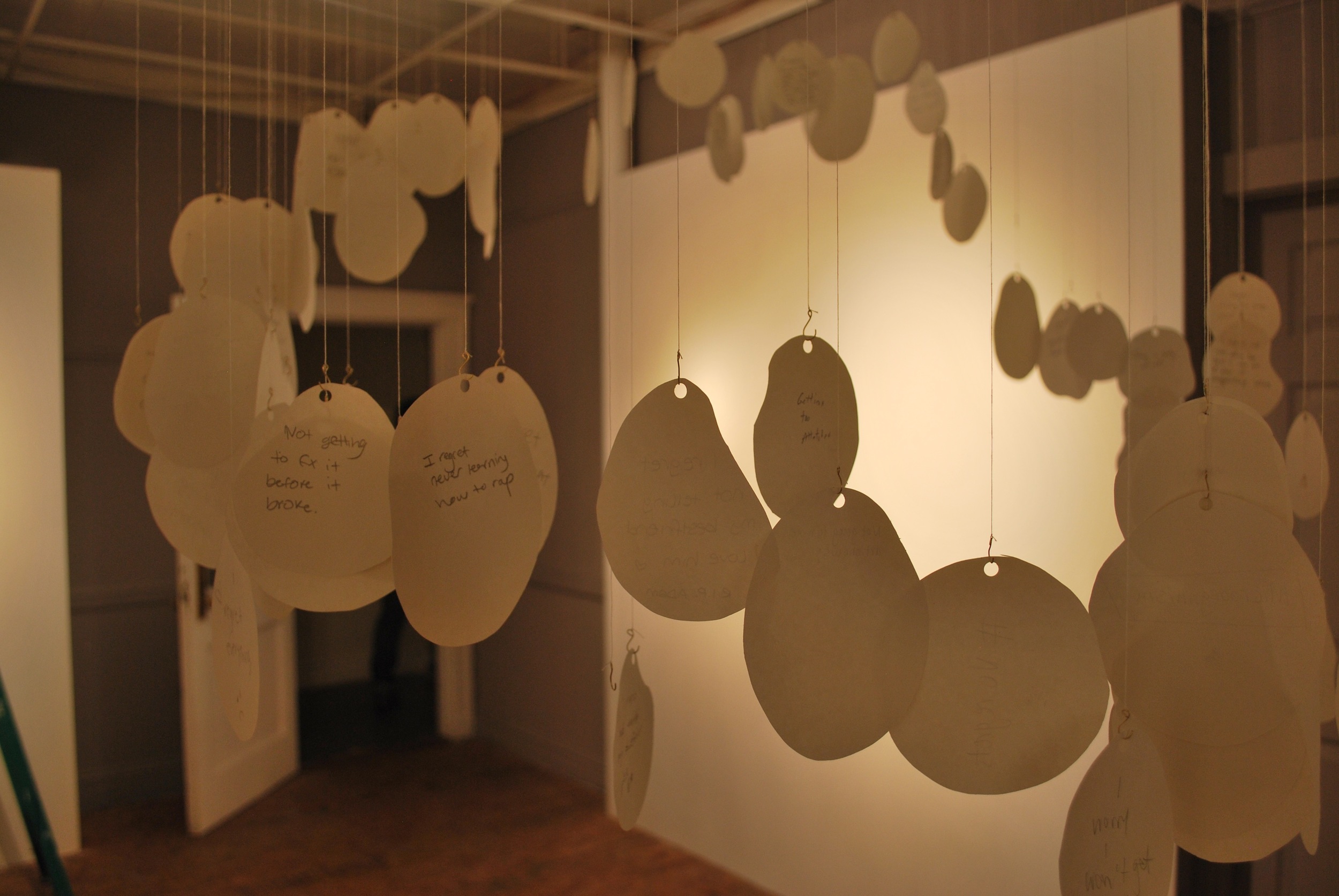 Paper circles hanging from string in art gallery in Boston MA Shannon May Mackenzie
