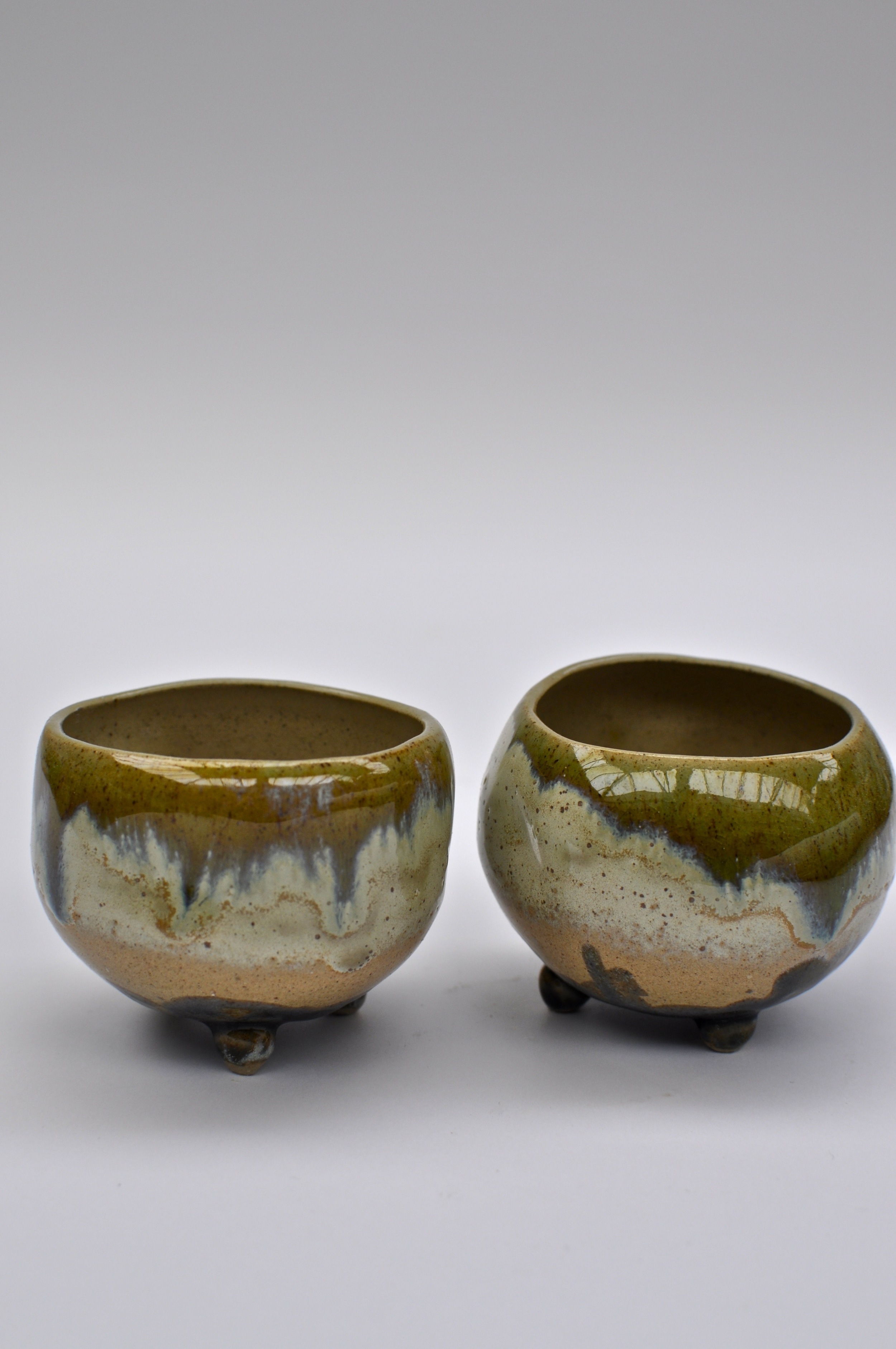Warm and green toned tea bowls with tripod feet by Shannon May Mackenzie