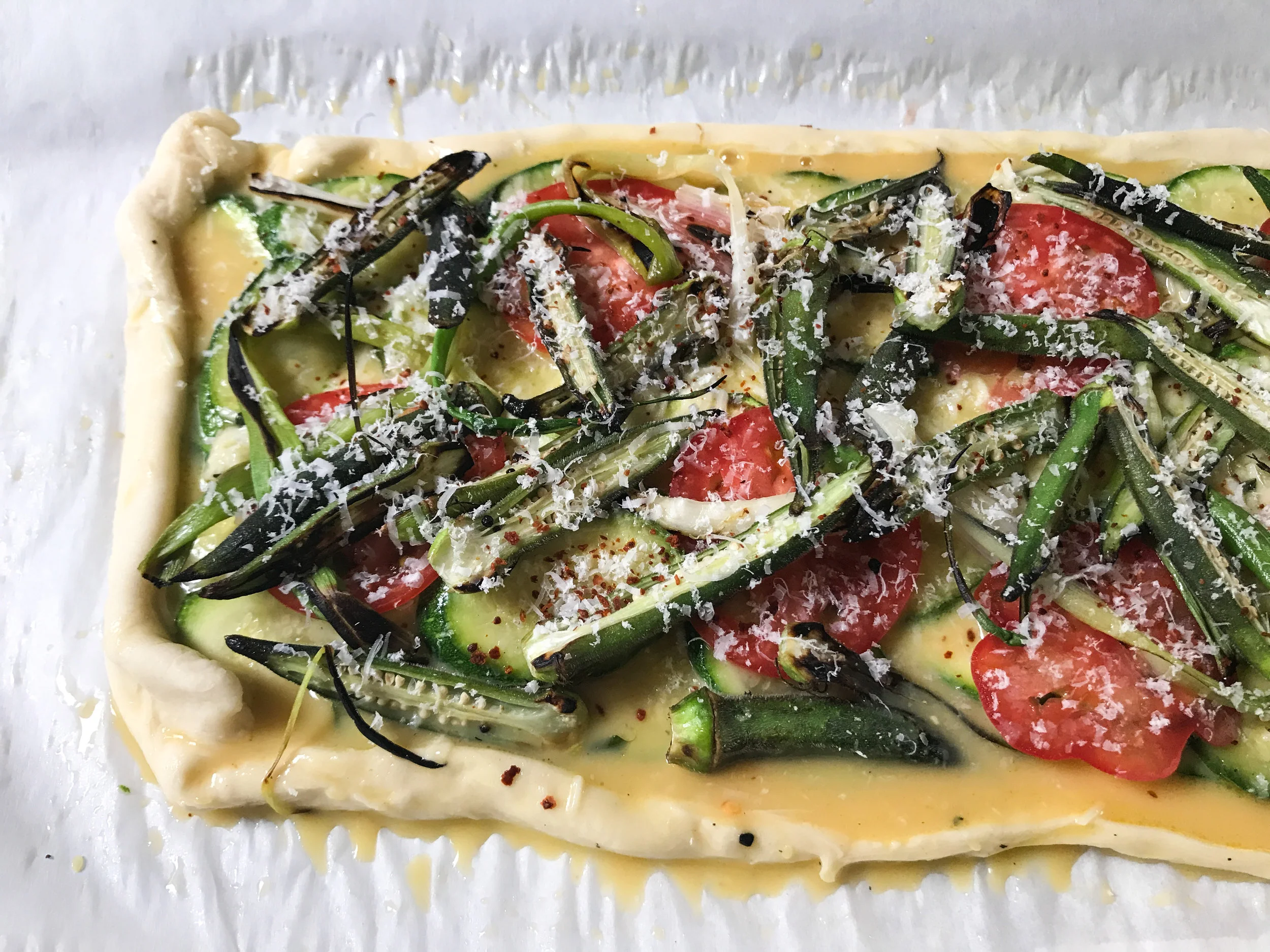My hastily-assembled zucchini, tomato and okra tart. With too much egg and sloppy edges, it spilled all over the parchment.