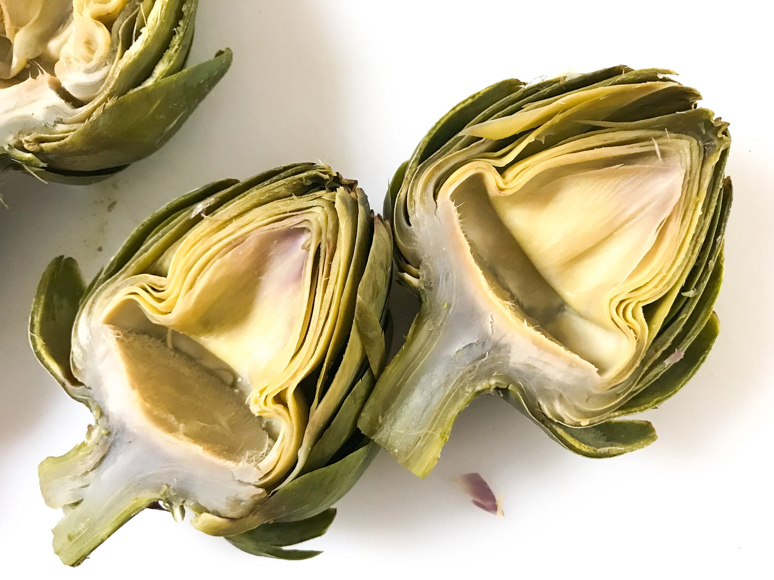 The boiled artichoke halves, after the fuzzy chokes and spiky inner leaves have been scooped out.