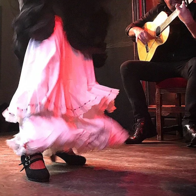female flamenco dancer’s feet and guitarist playing during a performance