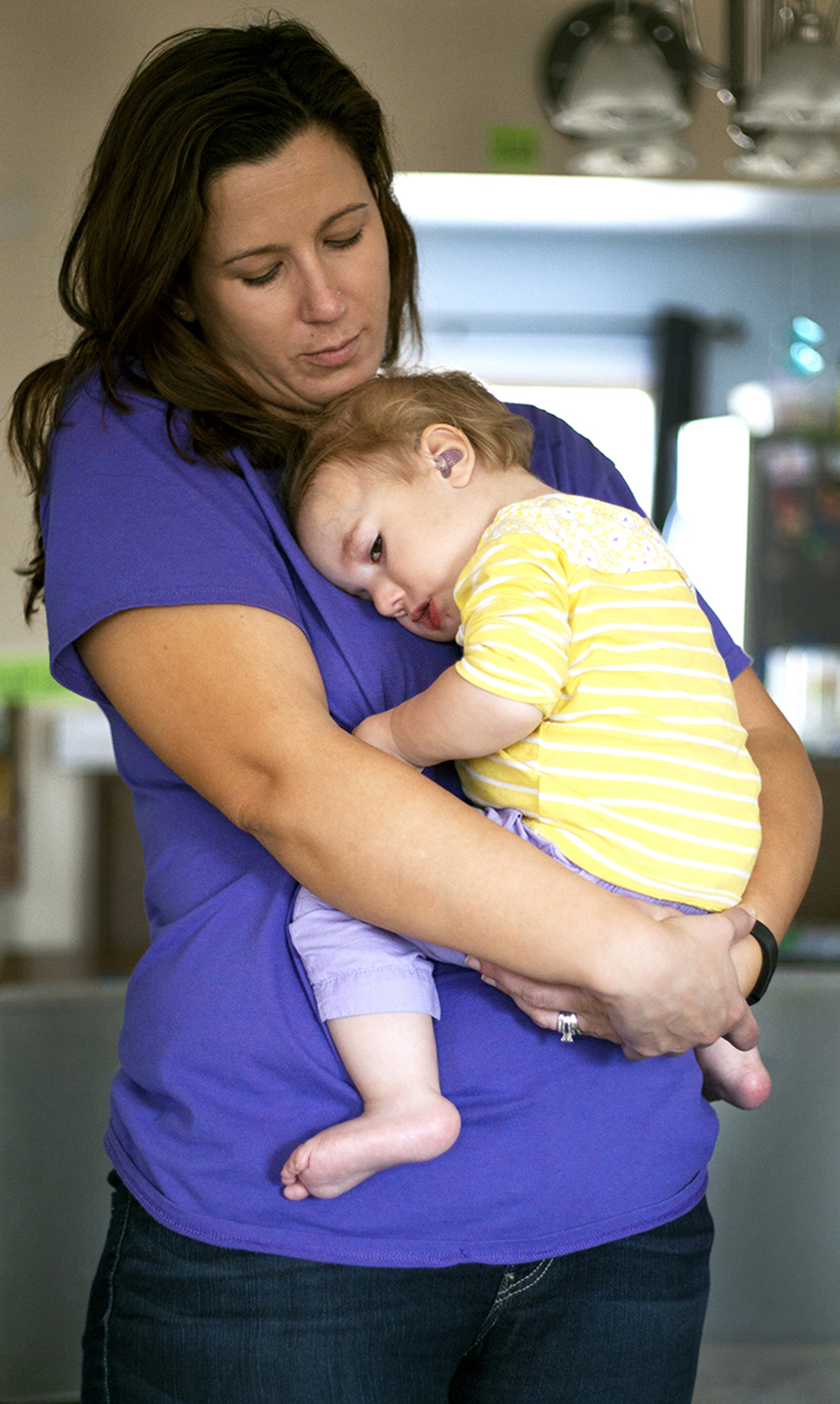 In-home nurse Beth McClelland holds and comforts Paysen Davis after a morning of schooling in the family home.