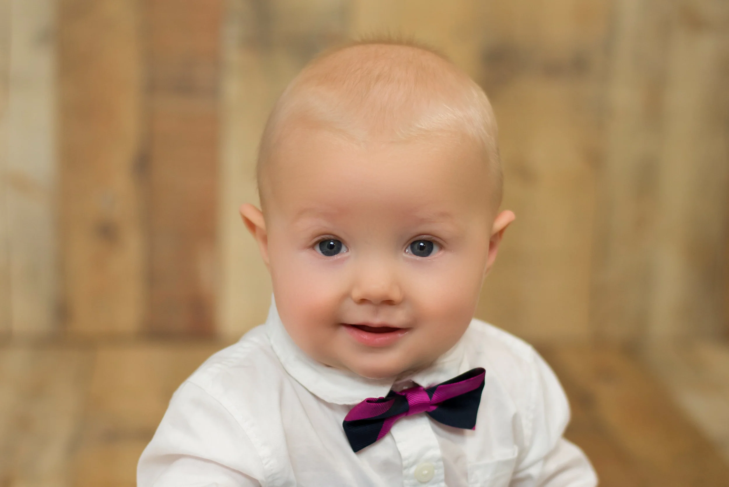 Wilmington nc photographer captures baby smiling while wearing a bow tie