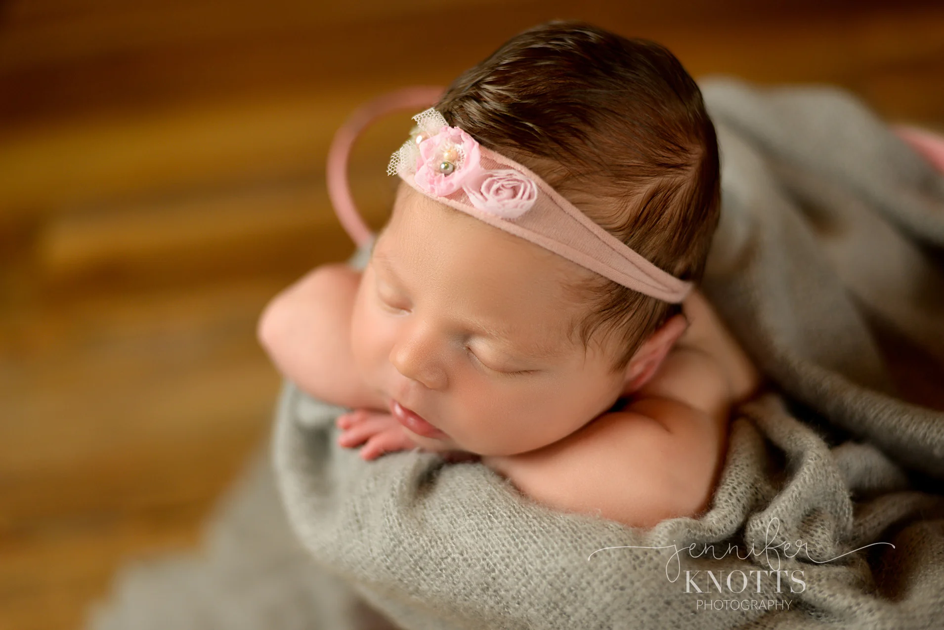 baby girl rests in bucket surrounded by gray fabric during Wilmington newborn session