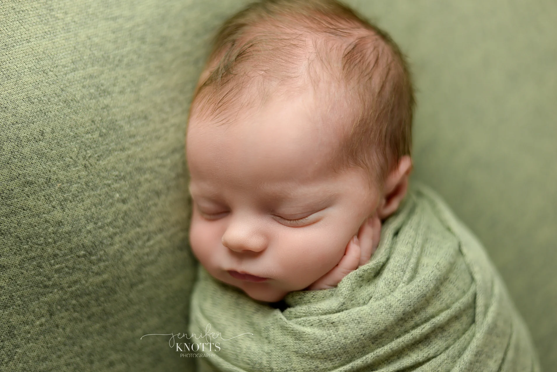 Wilmington newborn photographer captures baby boy wrapped in green