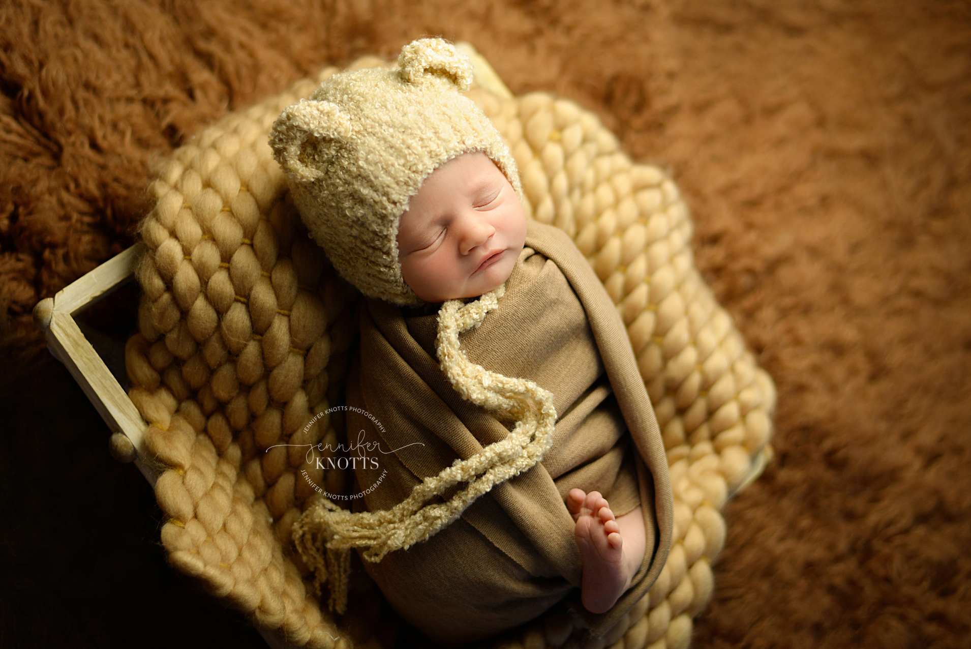 newborn photographer captures baby boy sleeping with bear bonnet