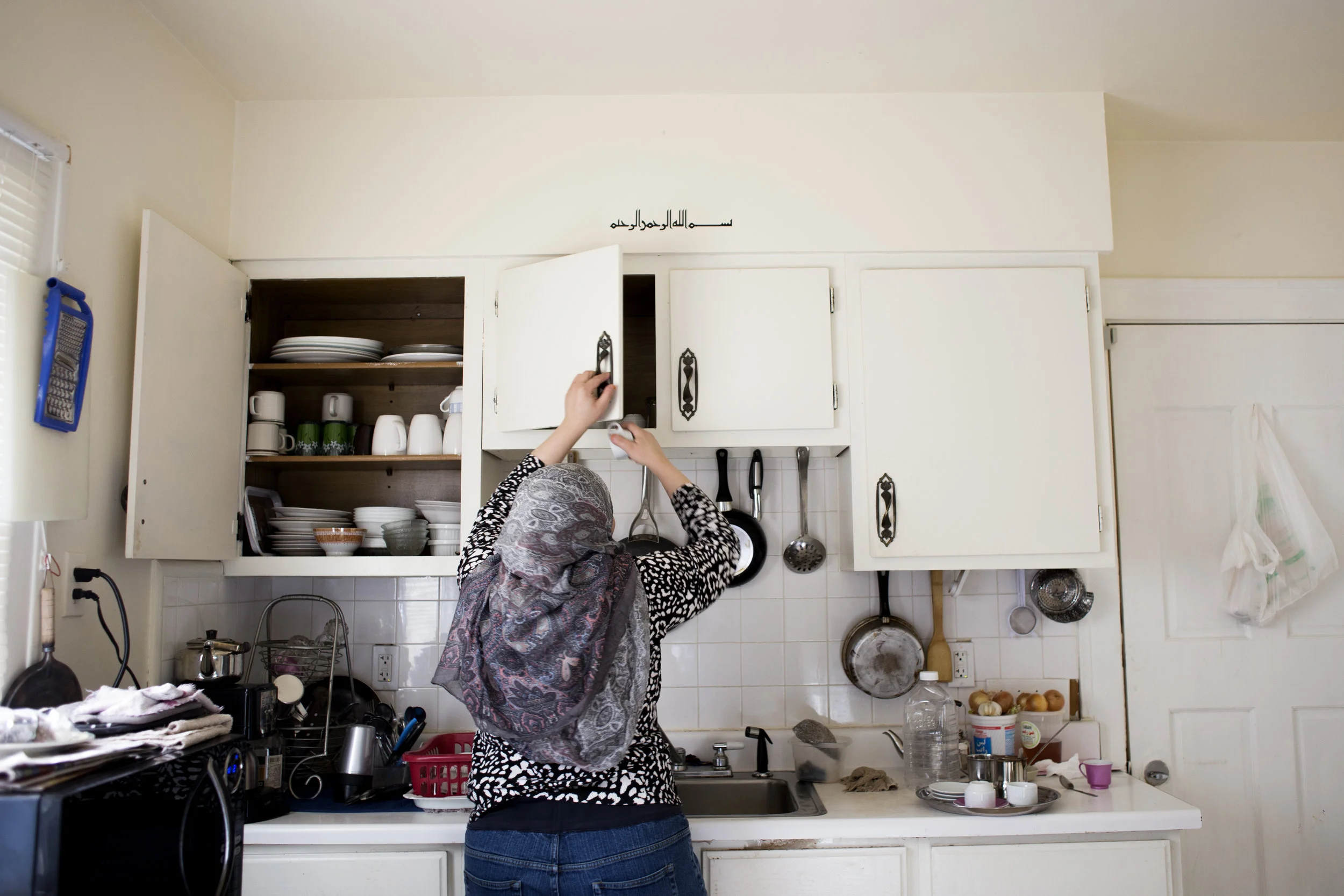 Above the cabinet reads "Bismillah alrahman alraheem," an Arabic phrase meaning, "In the name of God, the Most Gracious, the Most Merciful." Like many in America, preparing coffee is an essential ritual for the day.