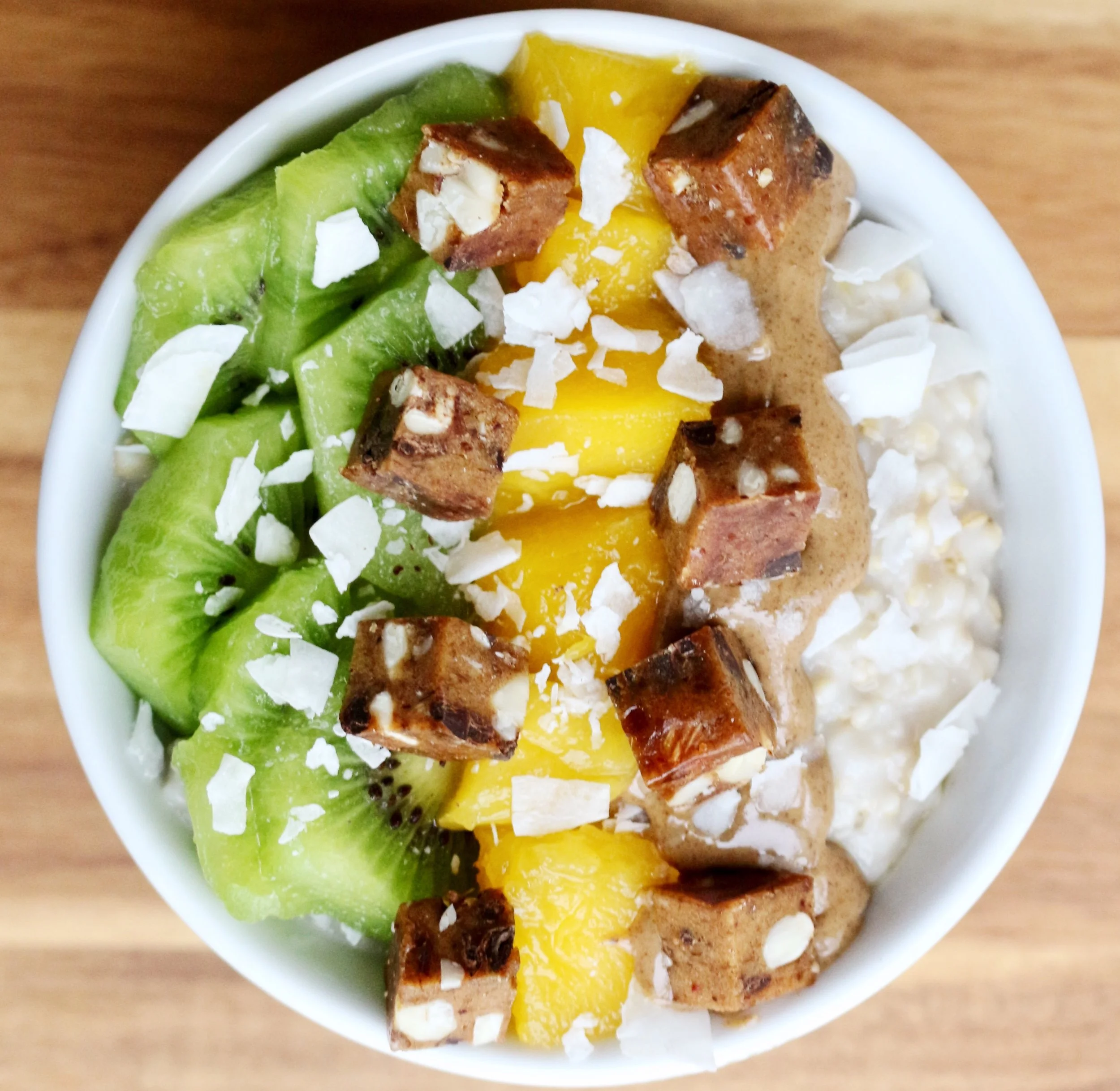Coconut Oatmeal with almond butter, mango, kiwi, rx protein bar chunks and flaked coconut. Oatmeal: Bring 1 cup of coconut milk to a boil and add ½ cup oats. After cooking add a scoop of protein powder and a pinch of pink salt.