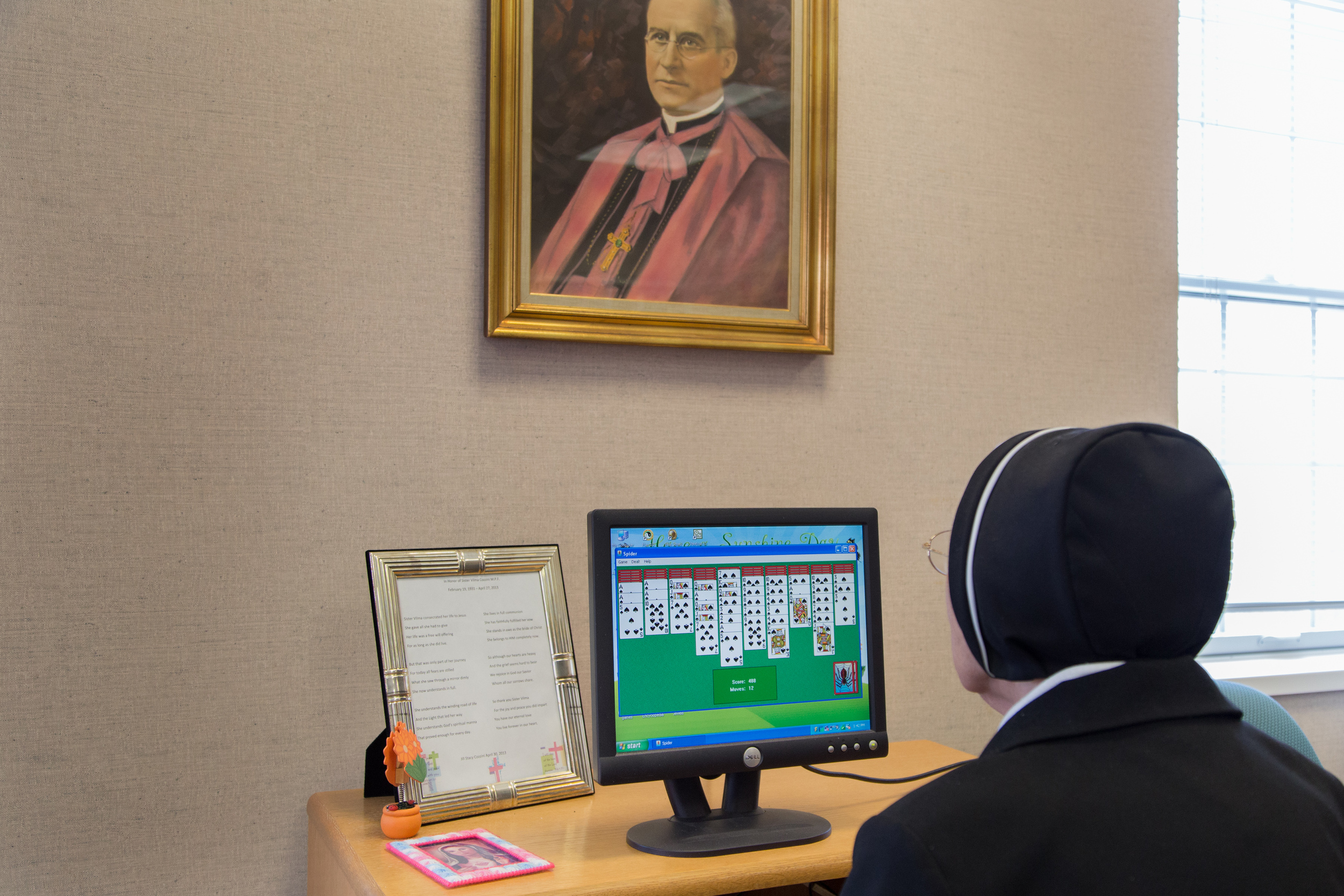  A Sister who works in the infirmary library, takes time out of her day to play an on-line game of Black Widow Solitaire. 