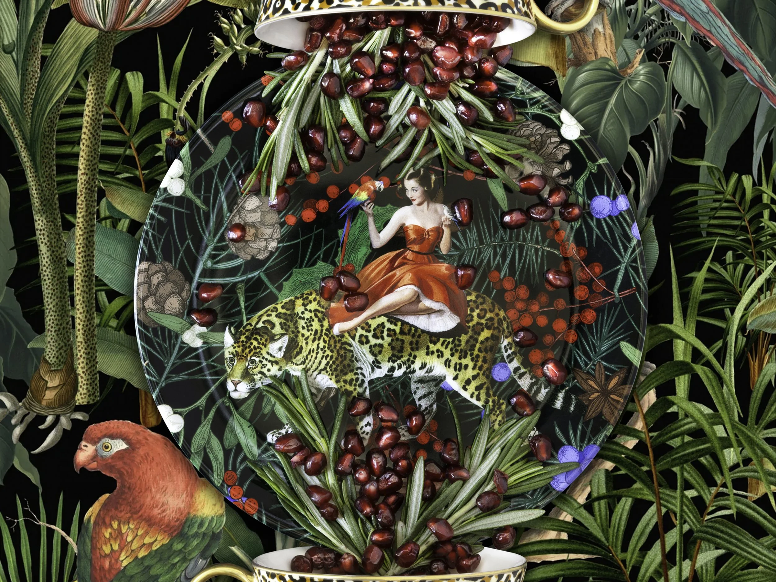 A decorative glass vase with a jungle theme, holding a bunch of pomegranate seeds and rosemary sprigs, surrounded by lush green tropical leaves and animals including a chimpanzee, a parrot, a leopard, and a red bird.