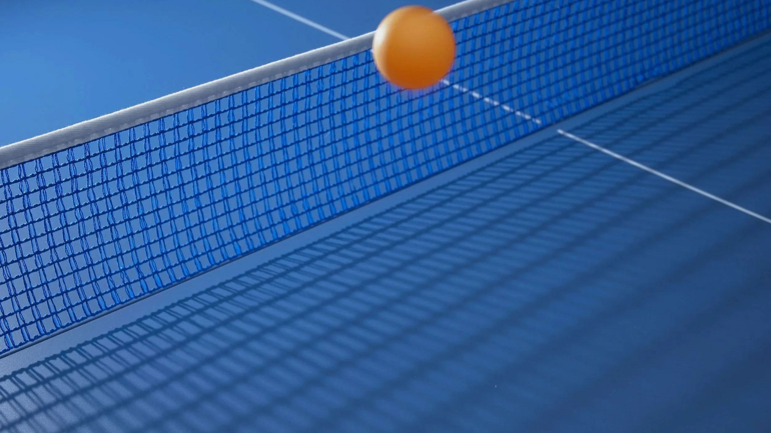 Tischtennisball über einem Tischtennisnetz
