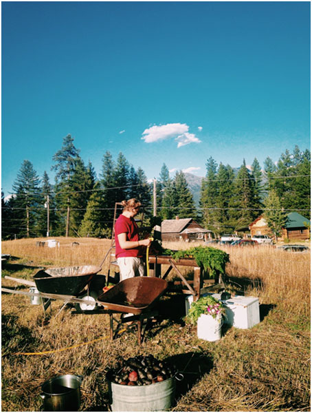 Evan washing heaps of potatoes, beets, and turnips