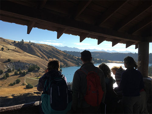 Andrea discusses the hydrology surrounding the dam with students, looking eastward toward the Mission mountains.