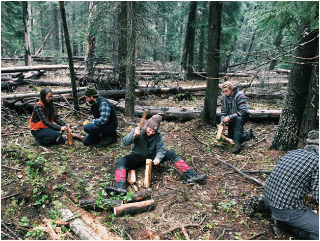 Kristen, Sophie, and Evan working on splitting rounds with a wedge they cut from the log