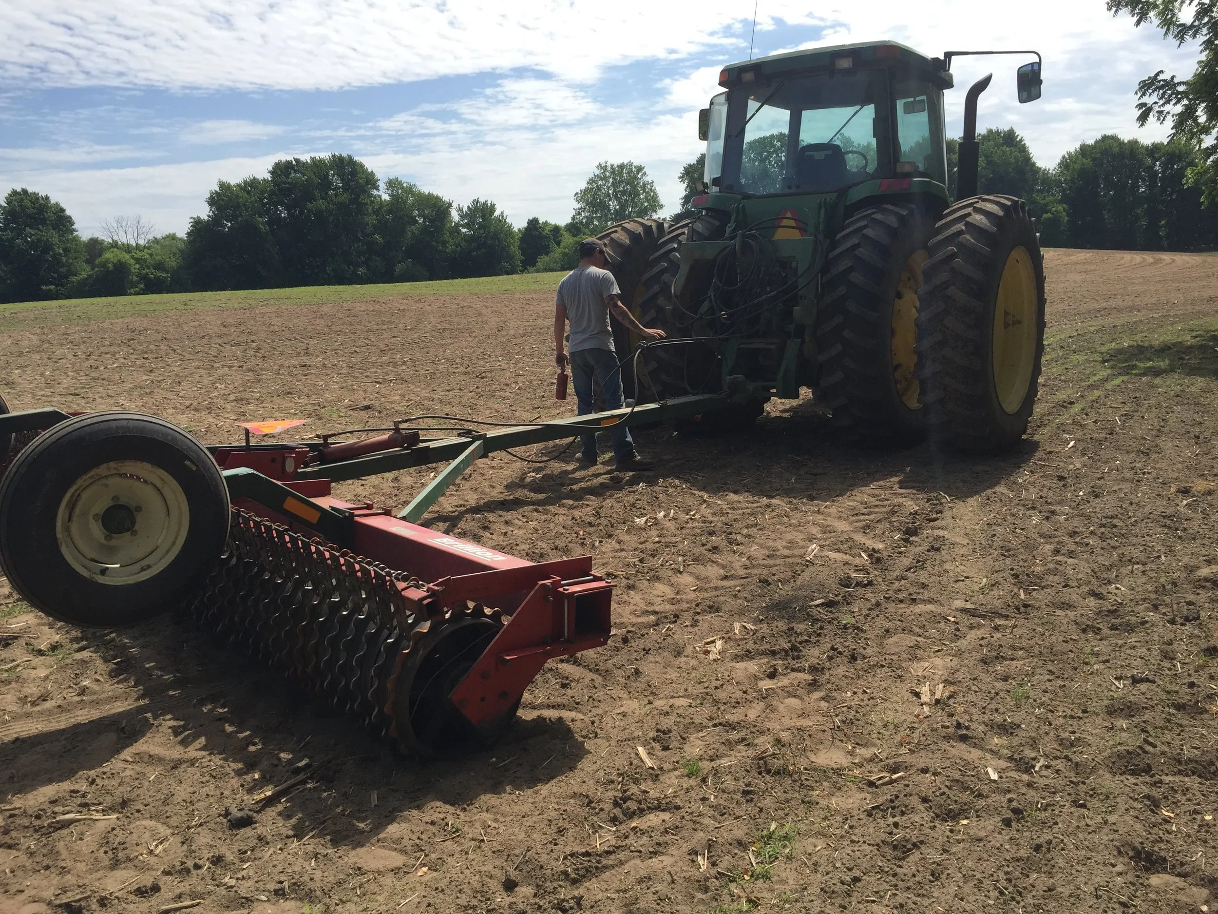 Hooking up the cultipacker. We ran it over the field again after we spread all the seeds. We did it just to drive them just a bit into the ground so that they didn't blow away. 