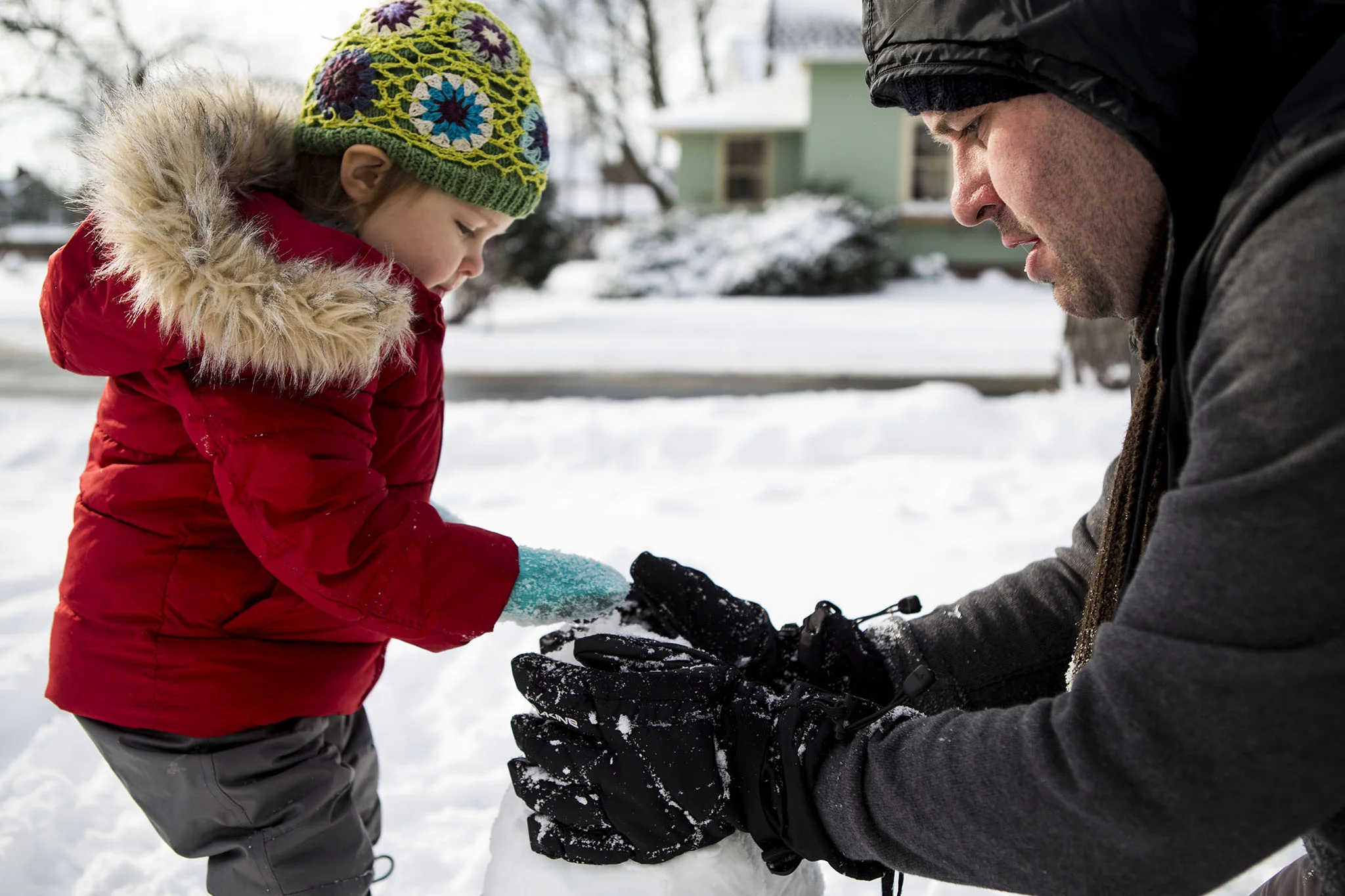 Father and daughter build a snow man in Connecticut