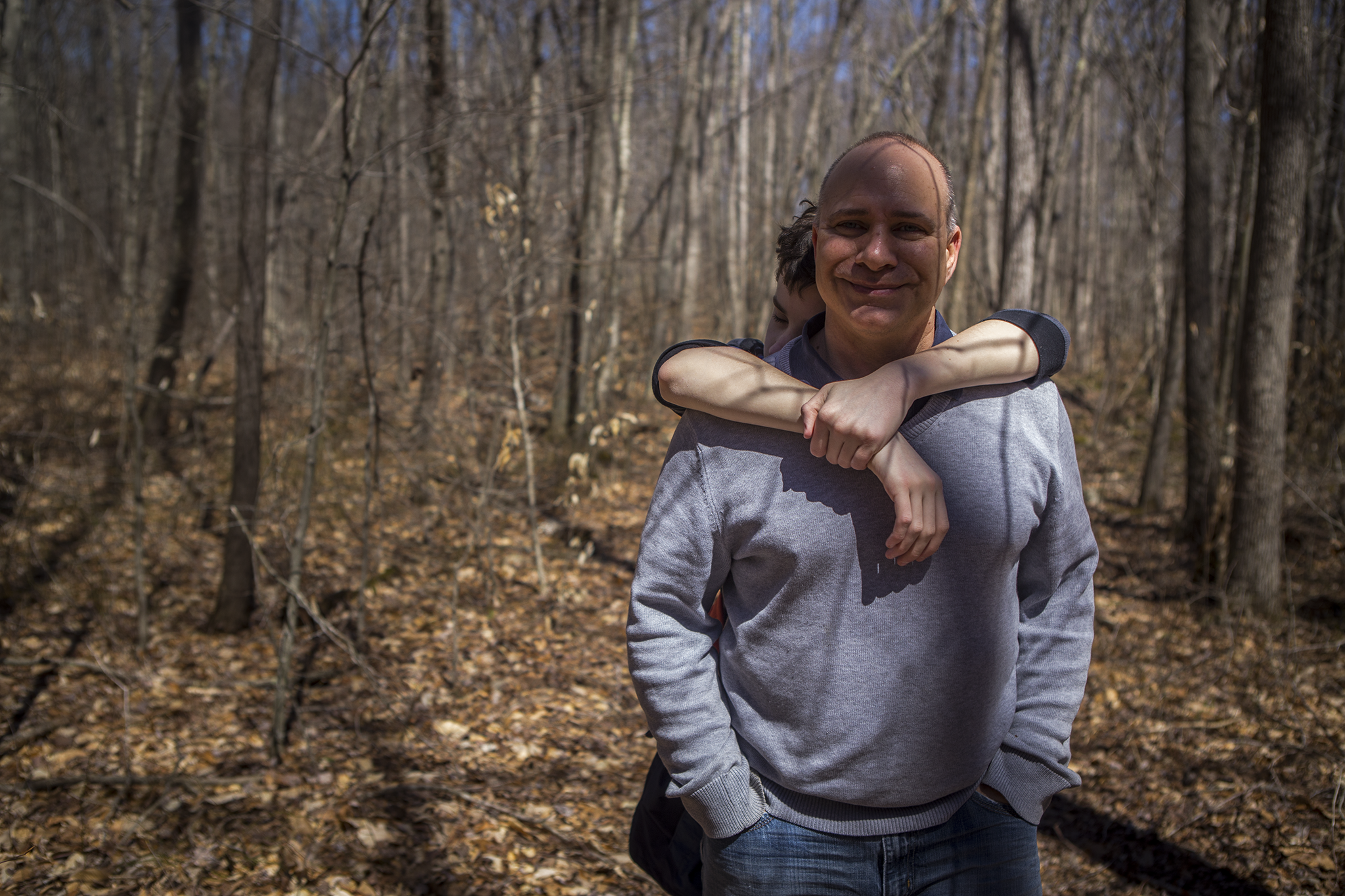 Candid photo of CT father and son walking through the woods.