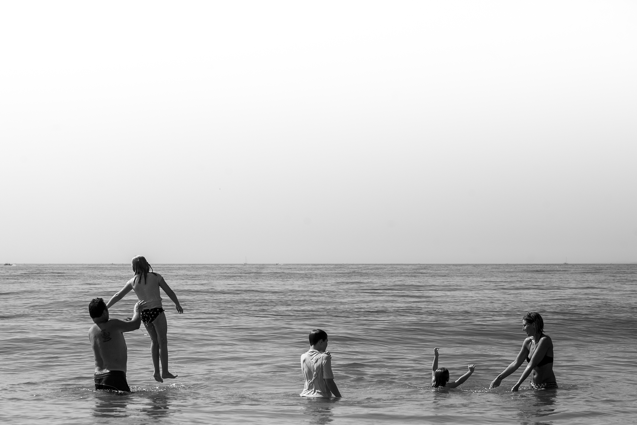 Beach family photography in ct, alternative authentic family portrait of the whole family swimming in the ocean.