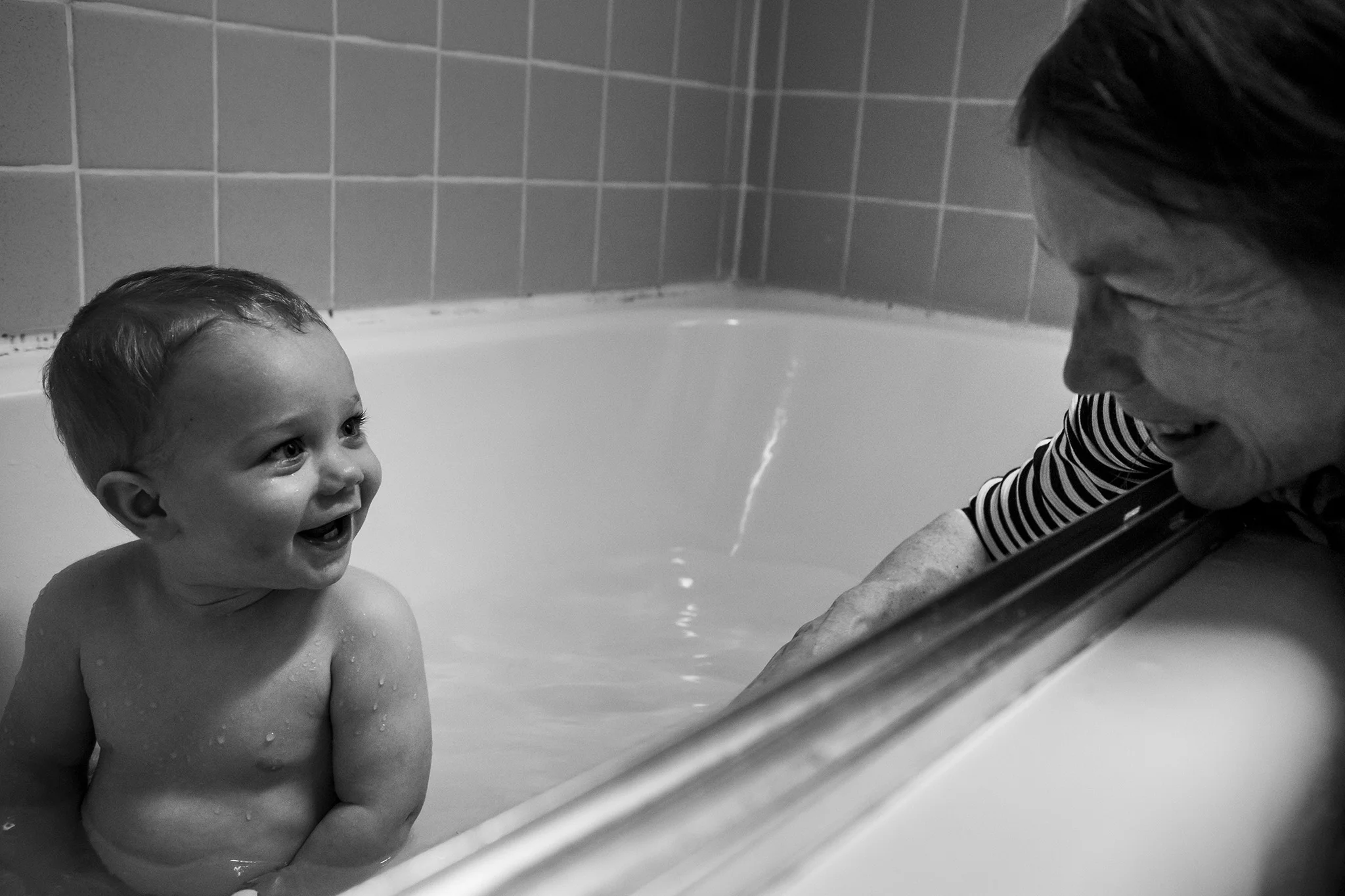 Bath time with grandma in this black and white candid family photo by Connecticut lifestyle photographer.