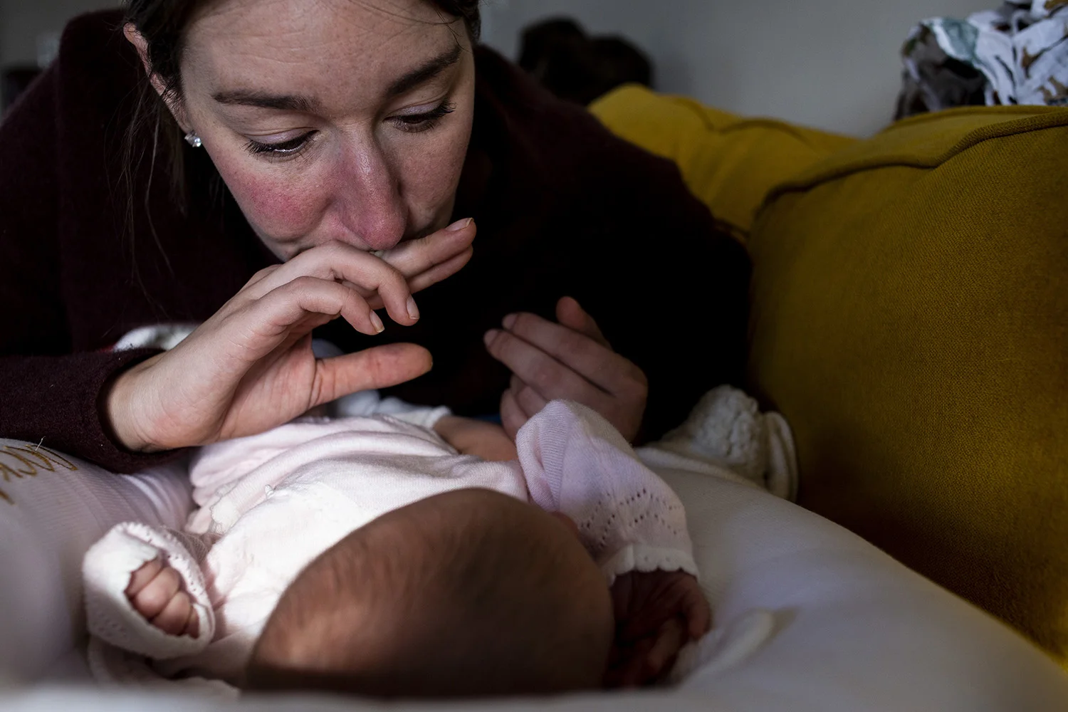 Boston Mom looks emotionally down at her newborn baby.