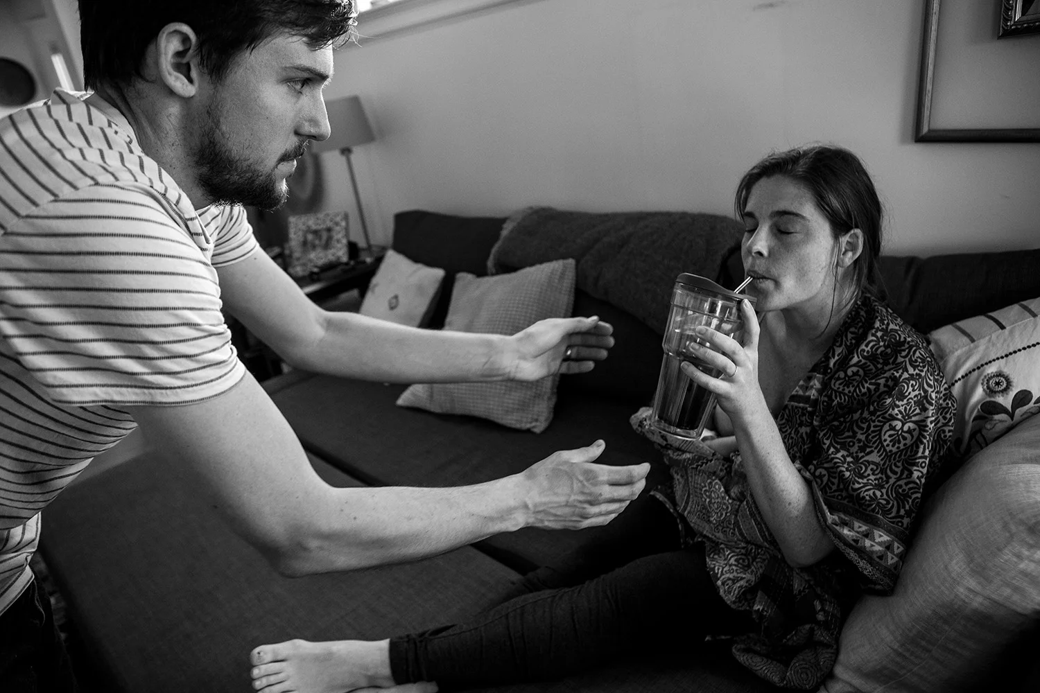 Boston newborn father helps mother hydrate.