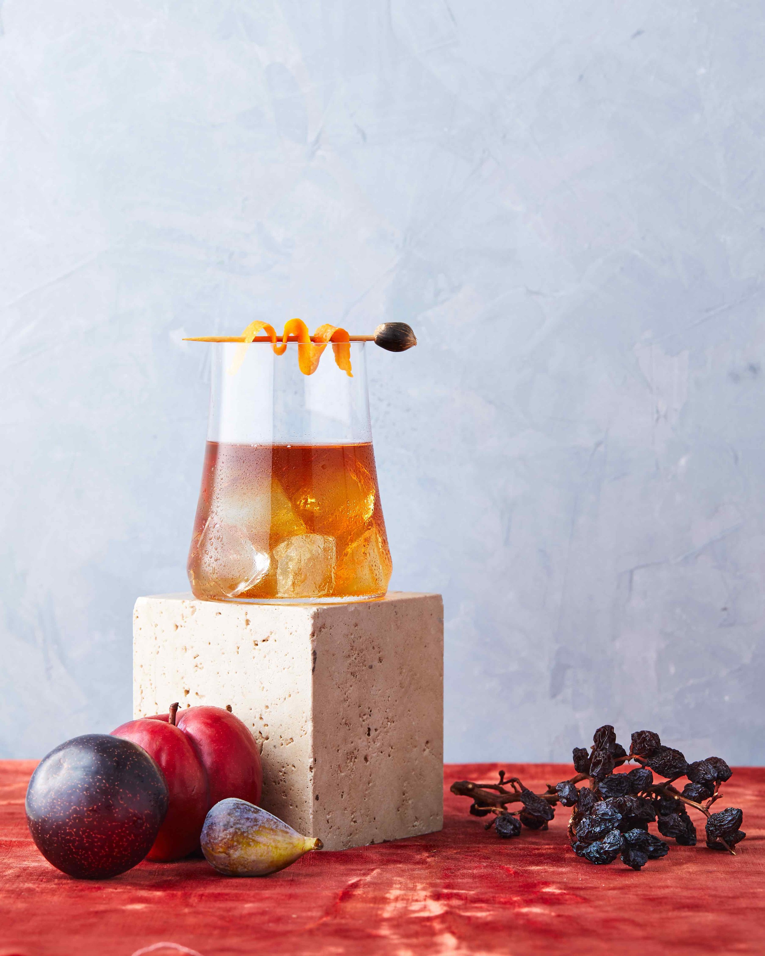 modern whiskey cocktail with plum and fig on red orange velvet.jpg