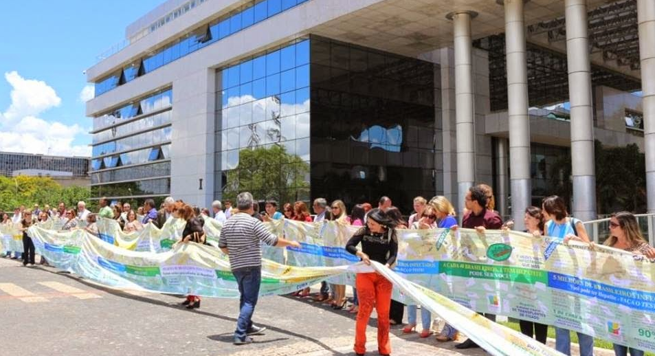 Pessoas de movimentos de enfrentamento às hepatites virais fazem abraço simbólico no Ministério da Saúde. (foto: Arquivo pessoal)