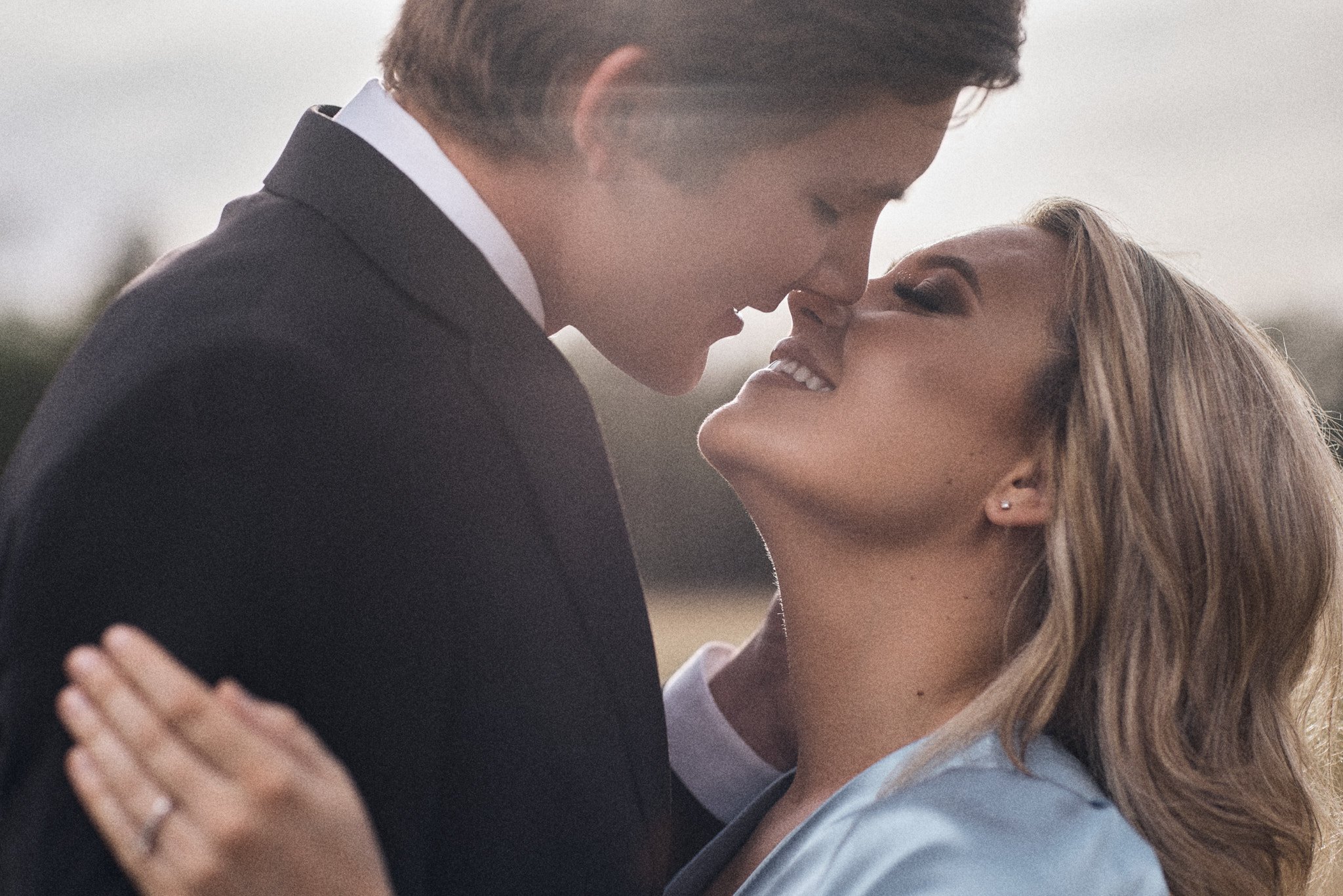 couple kiss during engagement session during golden hour