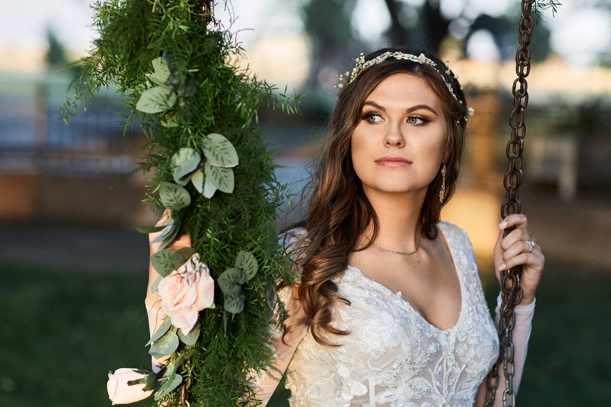 bride sits on a swingset during her wedding