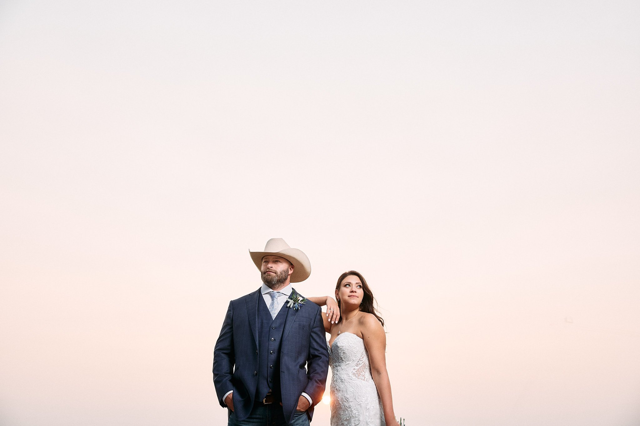 bride and groom pose under a texas sunset