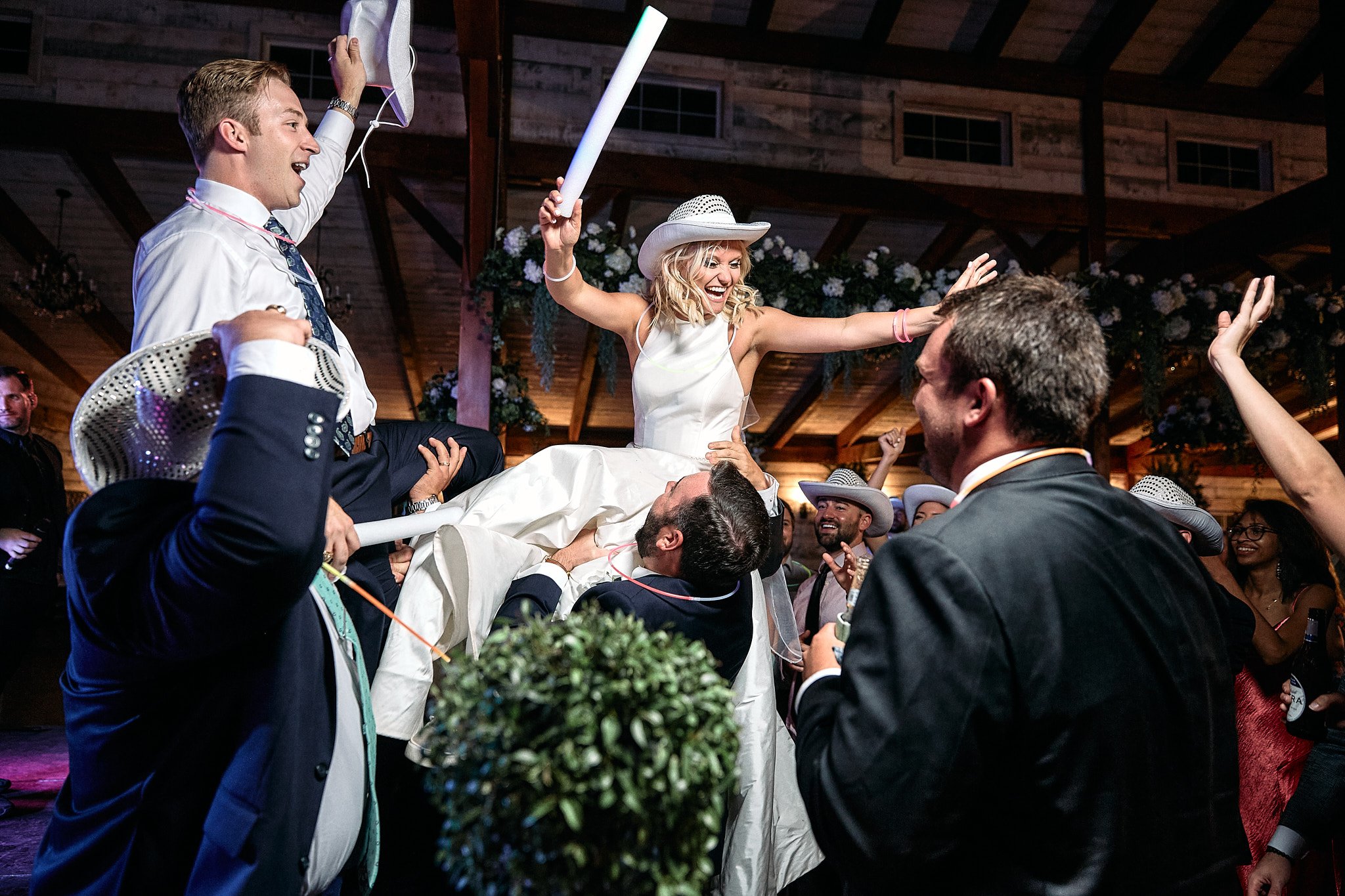 couple is held up by their wedding party during their wedding reception