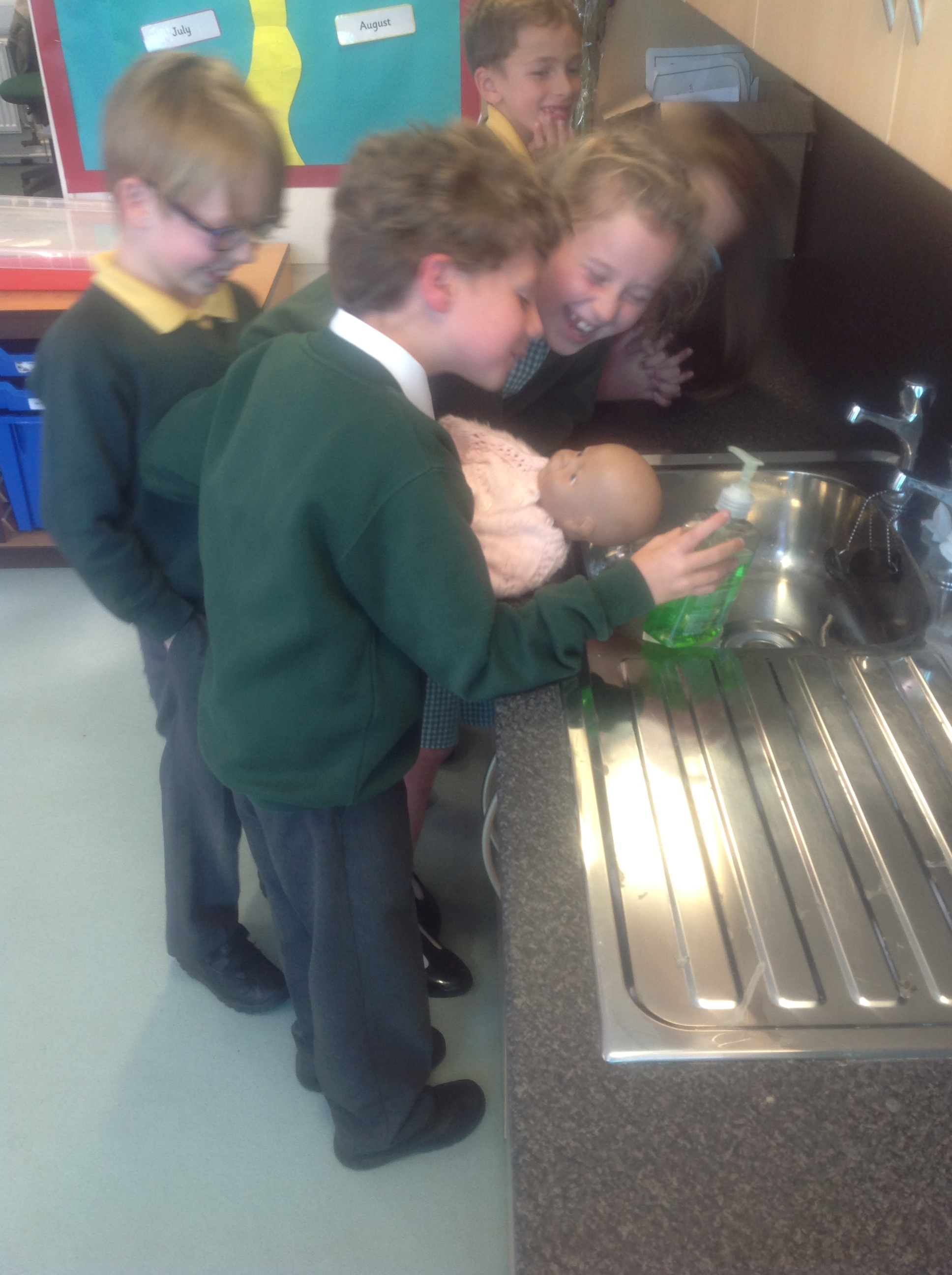 The priest blesses the baby and annoints them with special oil called chrism oil (here played by hand wash!)