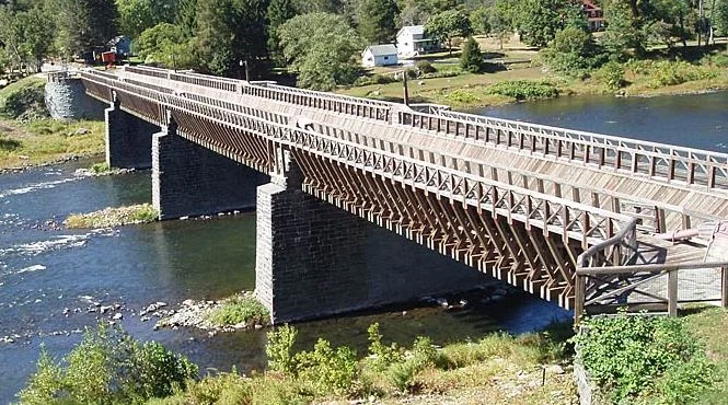 Roebling's Delaware Aqueduct, also known as the Roebling Bridge, is the oldest existing wire suspension bridge in the United States. It runs 535 feet over the Delaware River, from Minisink Ford, New York, to Lackawaxen, Pennsylvania. Built by the same man who built the Brroklyn Bridge.