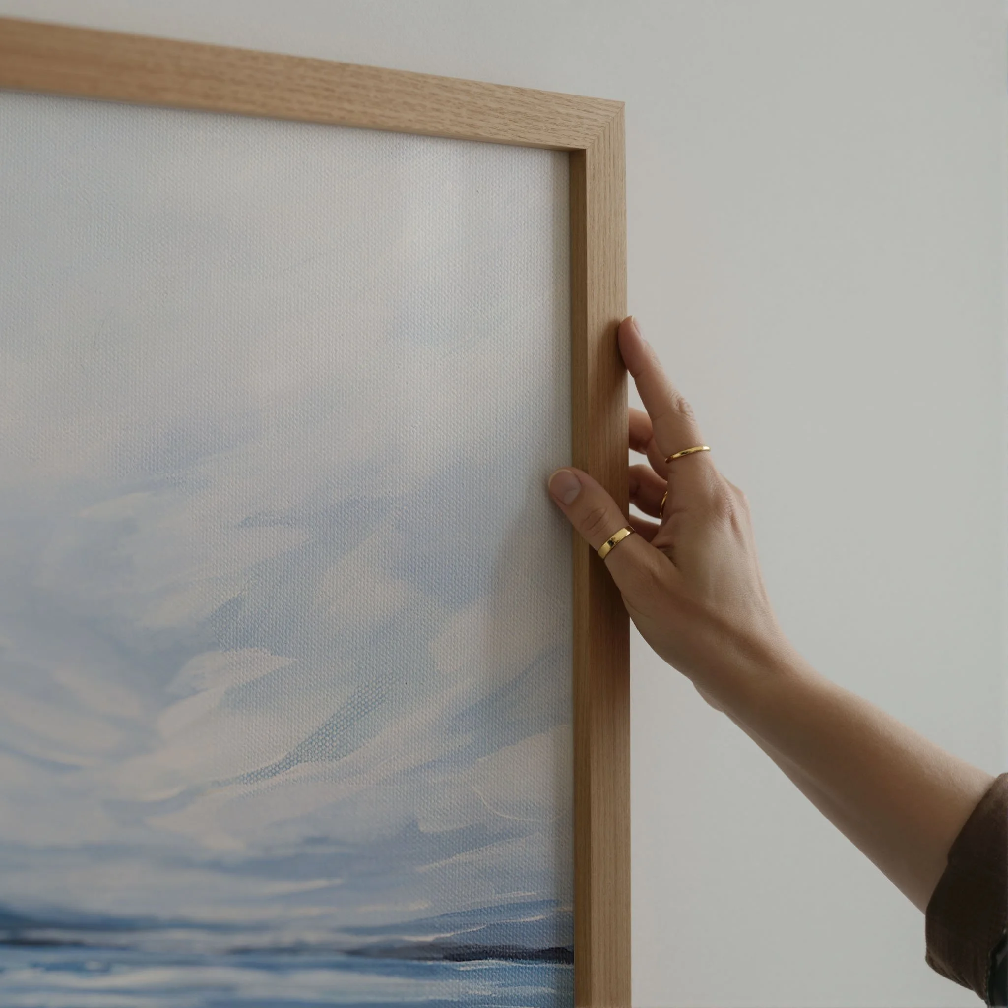 Close-up of an oak picture frame corner on a coastal print, showing natural wood grain and clean joinery, hand shown for scale. Print by Kendra Castillo, Bellingham Washington artist.