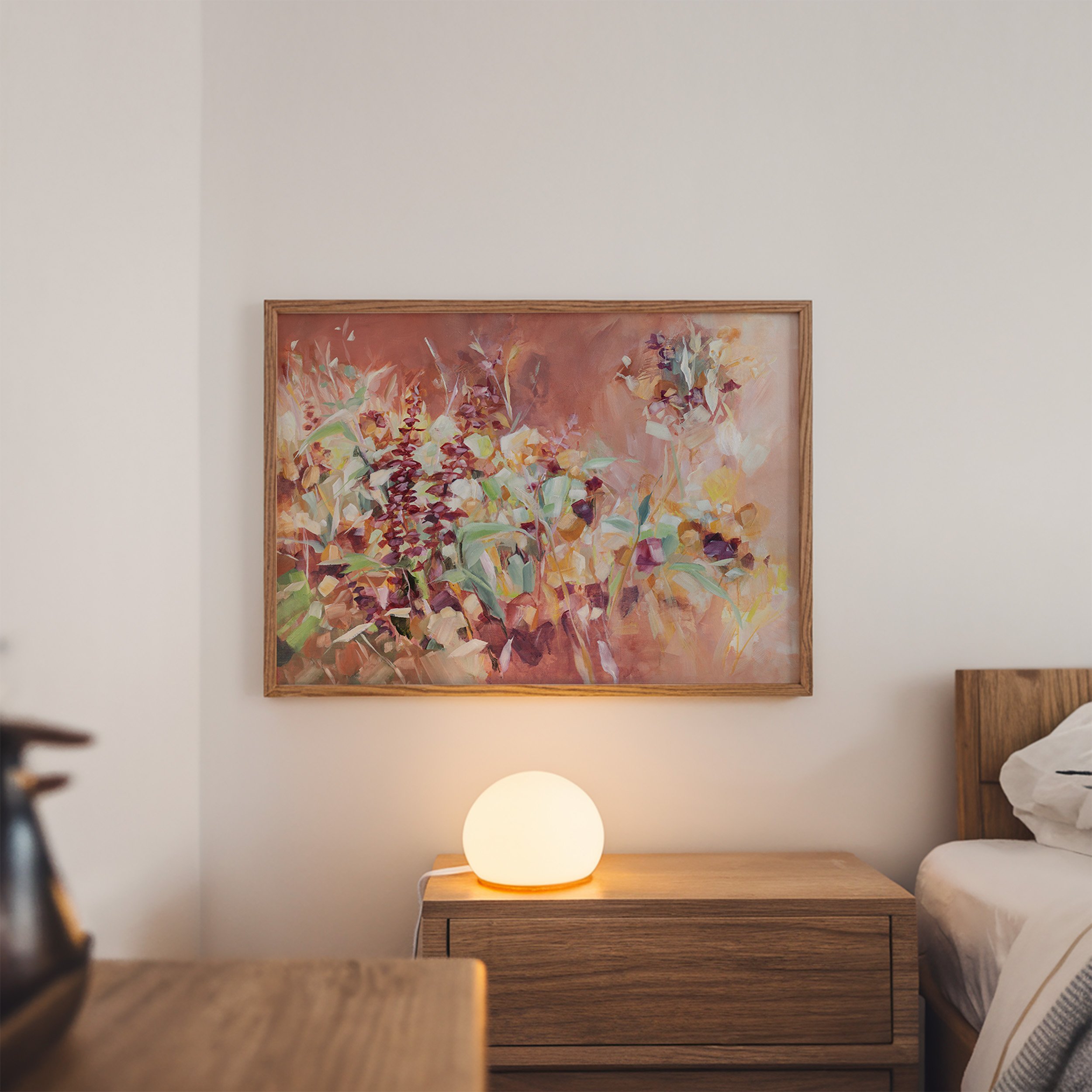 Framed abstract floral print by Kendra Castillo displayed above a nightstand in a cozy modern bedroom