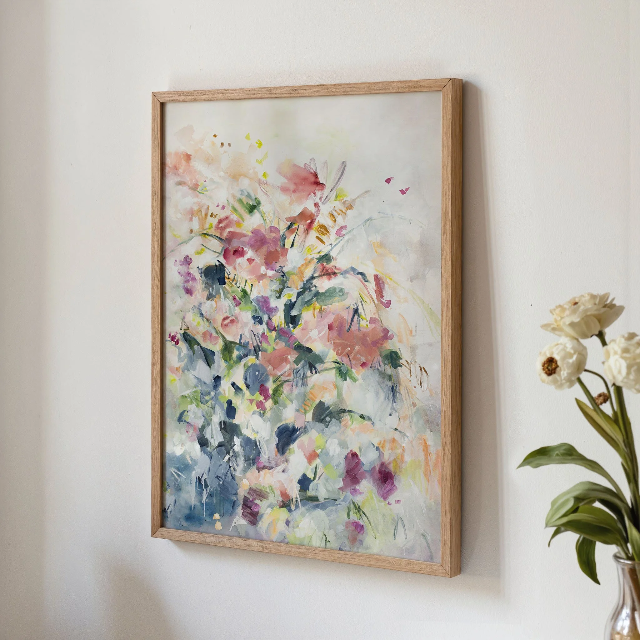 Framed Still Garden abstract floral art print by Kendra Castillo displayed on a neutral wall in a light wood frame.