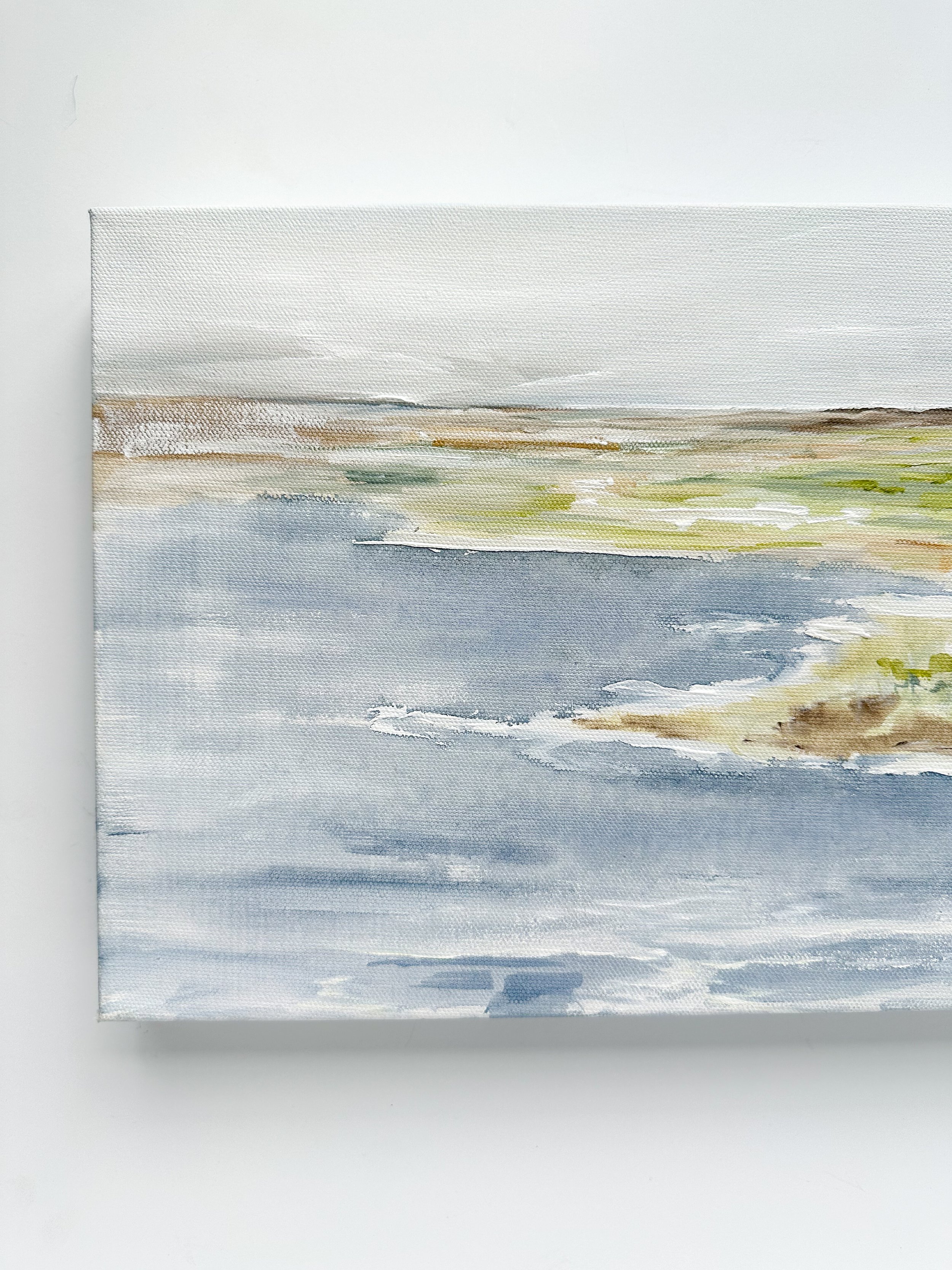 Horizontal original landscape painting with calm blue water and green shoreline