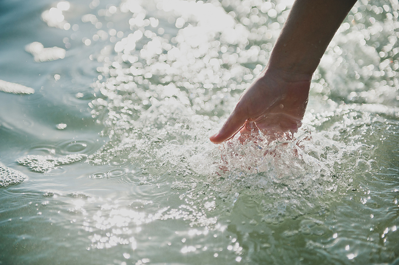 hand touching ocean wave