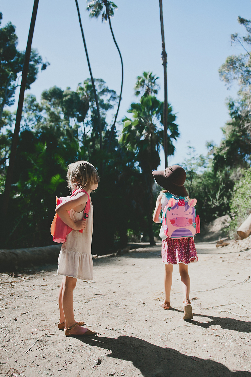 little girls wearing backpacks on dirt trail in California
