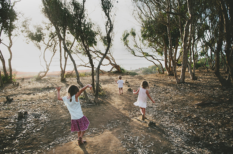 girls and boy walking on sandy path to ocean