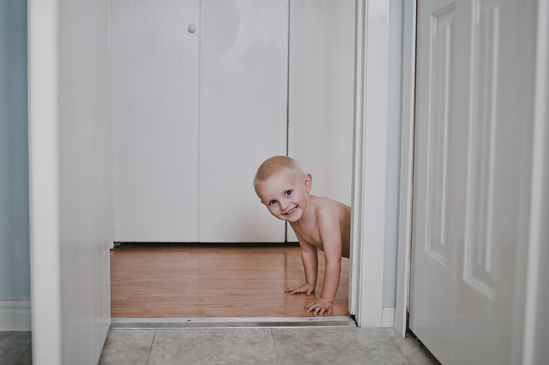 Toddler boy crawling on floor smiling