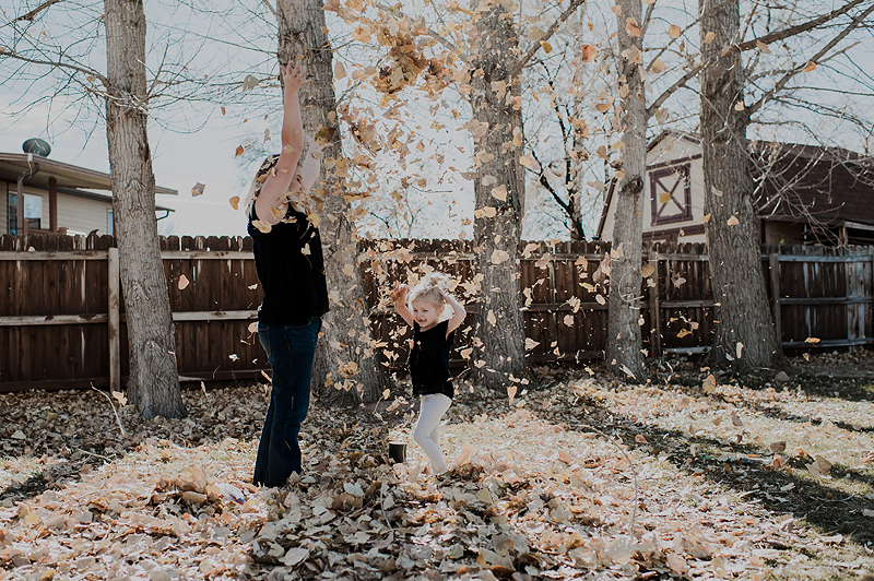 Throwing fall leaves in the backyard