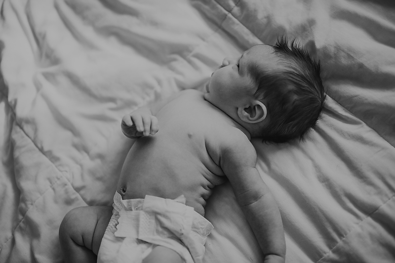 Newborn baby boy stretching in diaper