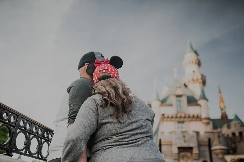 Couple at Disneyland park looking up at the castle.
