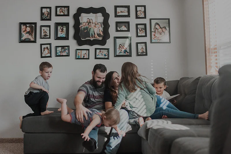 Family playing and snuggling on couch at home