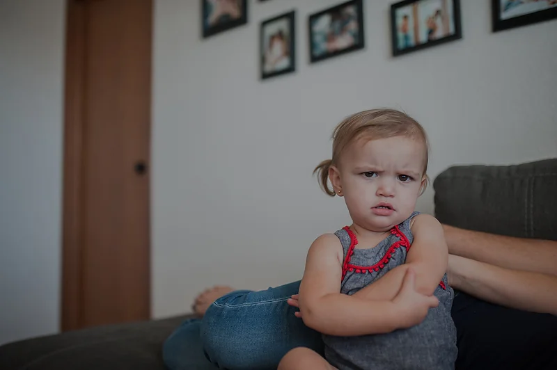 Baby girl pouting and folding arms